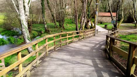 Pov-Caminando-Por-El-Paseo-De-Madera-Elevado-Y-Vacío-En-El-Parque-Local-En-Ordes,-Coruña