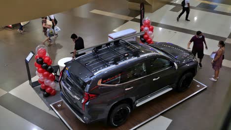 Husband-selling-his-wife-the-idea-of-buying-a-new-SUV-at-a-car-display-inside-a-Cebu-City-Mall,-Philippines