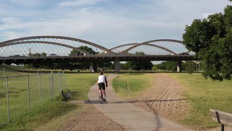 Drohnenvideo-Von-Radfahrern,-Die-Auf-Einem-Radweg-In-Der-Nähe-Von-Trinity-River,-Fort-Worth,-Texas-Und-Der-7th-Street-Bridge-Fahren
