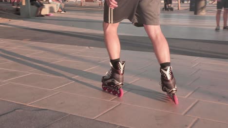Slow-motion,-close-up-on-person's-feet-roller-blading-on-pavement-during-golden-hour