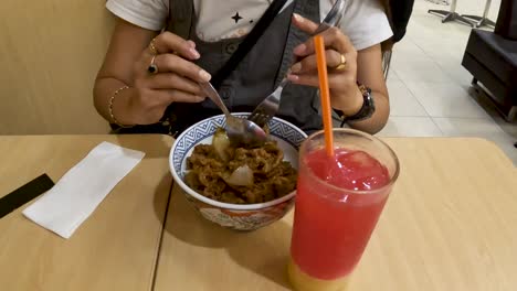 Unrecognizable-woman-eat-Japanese-food-in-restaurant-in-Yogyakarta,-Indonesia