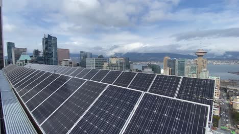 Panoramic-view-of-solar-panel-installed-on-roof-with-Vancouver-city-skyline-modern-metropolitan-skyscraper-building-and-harbour-of-the-Canadian-modern-eco-friendly-sustainable-smart-city
