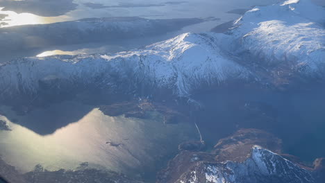 Beautiful-aerial-view-of-Bodo-Saltstraumen,-Bodo-Norway-northern-Norway,-snow-capped-mountains-and-golden-sun-reflected-on-the-water