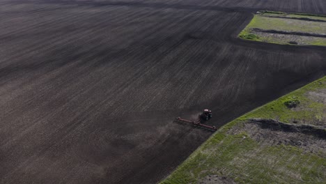 Luftaufnahme-Eines-Traktors,-Der-Ein-Großes-Unbepflanztes-Feld-Kultiviert