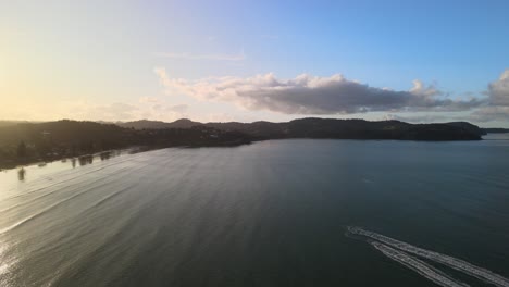 Flying-drone-past-2-jet-skis-on-New-Zealand-North-Island-beach-at-sunset