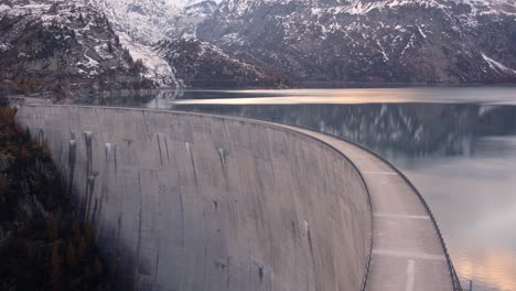 Massiver-Damm-In-Einem-Bergsee-Bei-Sonnenuntergang