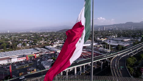 Disparo-De-Dron-Hacia-Arriba-De-La-Bandera-Nacional-De-México-Durante-El-Día-Ventoso