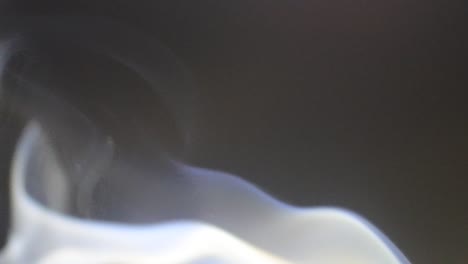 smoke-from-mosquito-coil-in-slow-motion,-White-smoke-slowly-floating-through-space-against-dark,-Atmospheric-smoke