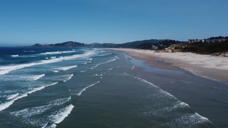 Zoom-in-drone-shot-flying-over-waves-at-Nye-Beach-on-the-Oregon-coast-in-the-small-town-of-Newport
