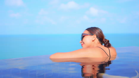 Schöne-Frau-Im-Infinity-Pool-Des-Tropischen-Resorts-Mit-Herrlichem-Blick-Auf-Den-Meereshorizont