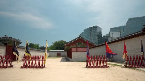 Gyeongbokgung-Palace-wooden-old-style-protective-fence-against-horse-riding-warriors-with-Historic-Korean-flags-used-during-Changing-of-the-Guard-re-enactment,-no-people