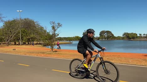 images-of-a-large-lake-in-the-middle-of-brasilia-city-park-with-a-cyclist-passing-by-on-a-summer-day