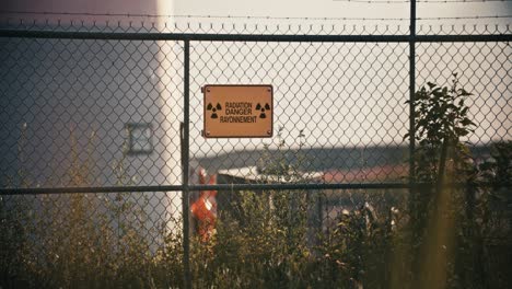 Wide-Shot-of-Radiation-Danger-Sign-in-Exclusion-Zone-Barbed-Wire-Perimeter-Fence-in-Slow-Motion-4K