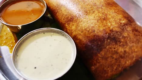 A-tempting-video-of-dosa-with-sambar-and-white-coconut-chutney-served-in-a-steel-plate