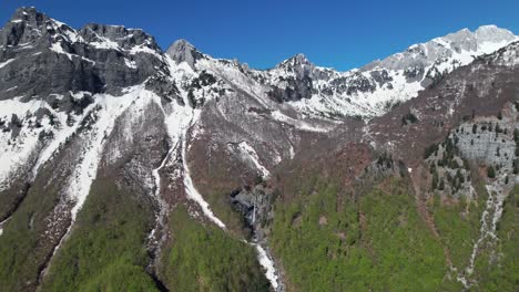 Principios-Del-Día-De-Primavera-En-Las-Montañas-Alpinas-Cubiertas-De-Nieve-Y-Bosques-Verdes