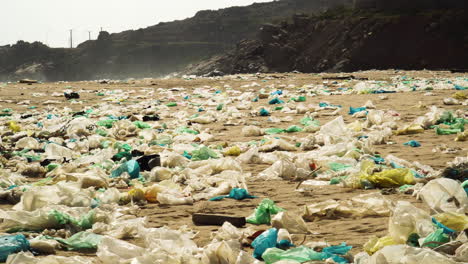 Garbage-scattered-on-Vietnamese-beach,-flying-in-wind