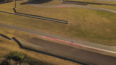 Aerial-drone-tracking-shot-of-racing-car-driving-on-track-during-competition
