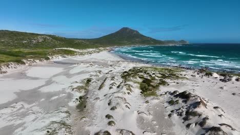 Low-flight-above-rugged-sandy-beach-towards-distant-Cape-of-good-hope-mountain