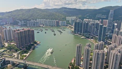 Tráfico-De-Barcos-Frente-Al-Mar-Tsuen-Wan-Con-La-Impresionante-Torre-Nina,-Hong-Kong