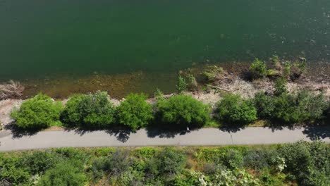 Top-down-aerial-shot-of-someone-jogging-on-the-Spokane-River-Centennial-State-Park-Trail