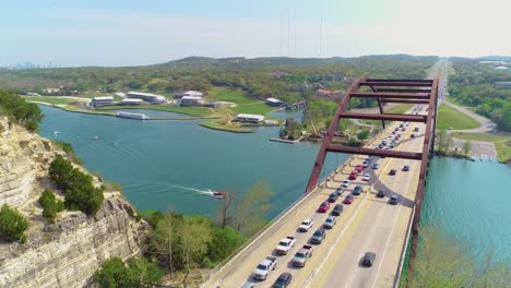 Bumper-to-bumper-car-traffic-on-the-Pennybacker-bridge-with-a-view-of-Austin,-Texas-in-the-upper-left-hand-corner