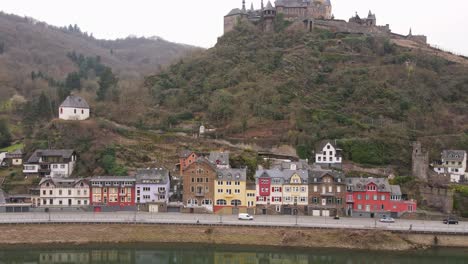 soaring-drone-flight-from-the-water-level-of-the-river-Moselle-to-the-castle-on-the-mountain-above-the-city-of-Cochem-in-Germany