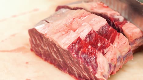 Close-up-of-hands-cutting-raw-meat