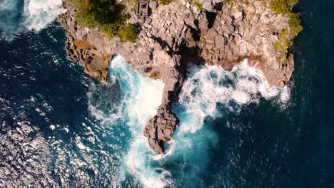 Aerial-riser-reveals-jagged-islet-in-picturesque-Crystal-Bay,-Nusa-Penida