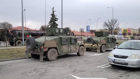 Tiro-De-Seguimiento-A-Lo-Largo-Del-Convoy-Militar-En-La-Calle-Przemysl,-Hummers-Del-Ejército-Estacionados-Cerca-De-La-Frontera-Con-Ucrania