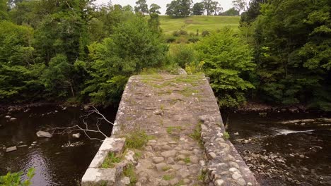 aerial-view-of-cobbled-pathway-over-cromwells-bridge-over-rolling-stream