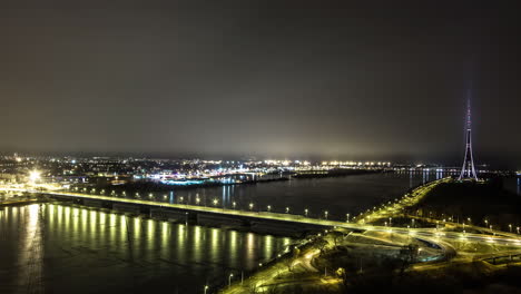Fahrzeuge,-Die-Nachts-Durch-Die-Straßenbrücke-über-Den-Fluss-Daugava-In-Der-Nähe-Von-Riga-Radio-Und-Tv-Tower-Fahren