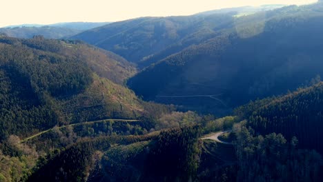 Aerial-forwarding-shot-of-hills-after-dawn-with-sunlight-shinning-in-Manón,-Lugo,-Galicia,-Spain