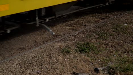 Closeup,-high-angle-slow-motion-shot-of-the-wheels-of-a-freight-train-passing-through-a-country-town