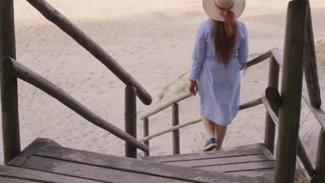 Carefree-Girl-Walk-Down-the-Wooden-Staircase-on-Beach,-Vacation-in-Summer