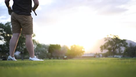 Golfista-Balanceándose-Y-Golpeando-La-Pelota-En-La-Calle-Del-Campo-De-Golf-Con-Bengalas-Solares