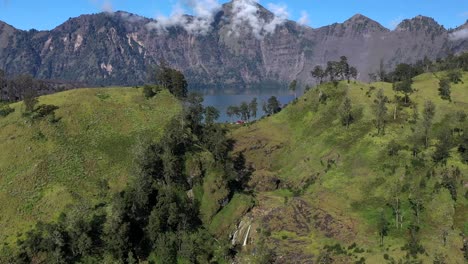 Campsite-on-the-wall-of-the-crater-lake-of-Mount-Rinjani-Volcano-in-Indonesia,-Nusa-Tenggara,-Aerial-rising-reveal-shot