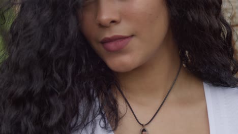 Ascending-camera-movement-to-reveal-a-young-curly-hair-girl-wearing-a-black-necklace