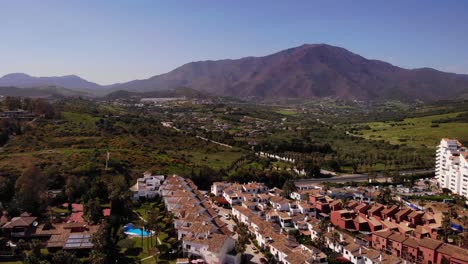 Luftaufnahme-Von-Ferienvillen-Mit-Berg-Im-Hintergrund-In-Estepona,-Costa-Del-Sol