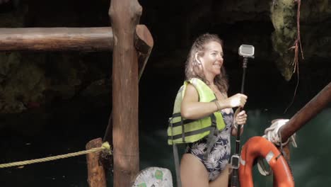 A-static-shot-of-a-beautiful-young-lady-putting-on-life-vest-at-cenote-at-night