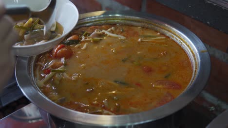 A-close-up-shot-of-a-girl's-hand-taking-cooked-vegetable-and-soup-in-buffet