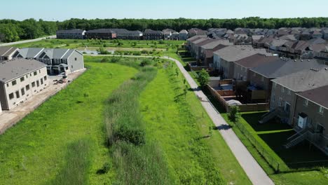 Outdoor-paved-nature-walking-path-in-community-neighborhood,-day-drone-aerial