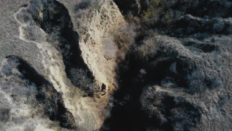 Eagle-eye-moving-forward-drone-shot-over-a-canyon-in-loess-soil-at-the-Allah-Bair-nature-reservation-located-in-Constanta-County,-Dobrogea-region-of-Romania