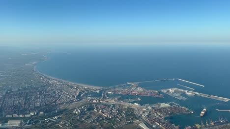 Aerial-view-from-a-jet-cockpit-of-Valencia-harbor-and-northern-coast-al-3000m-high,-pilot-POV,-in-a-splendid-june-afternoon