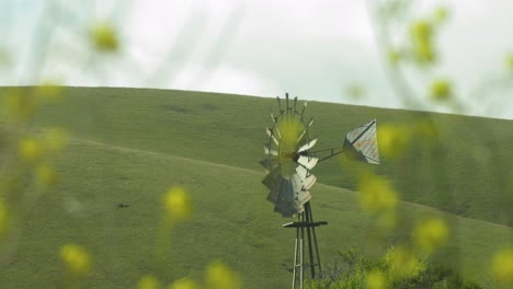 Windmühle-Vor-Pastoralen-Kalifornischen-Hügeln-Mit-Unscharfen-Blumen-4k