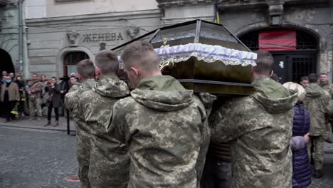 Ukrainian-soldiers-lift-a-fallen-comrade’s-coffin-on-to-their-shoulders-and-carry-it-past-onlookers-towards-the-entrance-of-the-Church-of-the-Most-Holy-Apostles-Peter-and-Paul