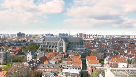 Aerial-shot-flying-high-over-the-historical-city-centre-of-Leiden,-the-Netherlands,-with-the-Pieterskerk,-Leiden-University-and-Rapenburg-canal