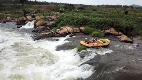Yellow-rafting-boat-rafting-down-the-Nile-River-waterfalls,-Jinja,-Uganda