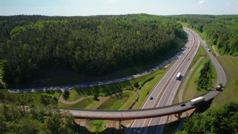4K-Drone-Footage-Of-Highway-Overpass-With-Trucks-In-Forest-Environment