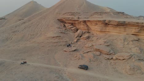 Group-Of-Friends-Standing-Sandstone-Rock-In-Desert-Landscape-In-Khairpur