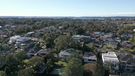 Aerial-view-of-residential-neighborhood-in-the-autumn-with-ocean-in-the-horizon